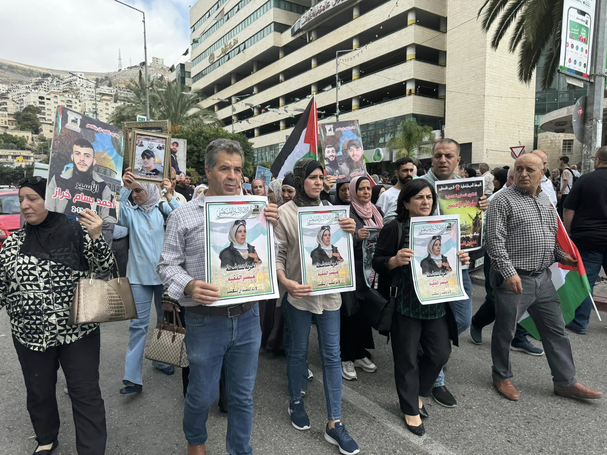 [Photo 1] A local demonstration at Nablus Square, Palestine, calling for the release of Maysar and other detainees. The three posters held by the protesters feature images of Maysar. This photo was sourced from the Facebook page of her husband, Wael.