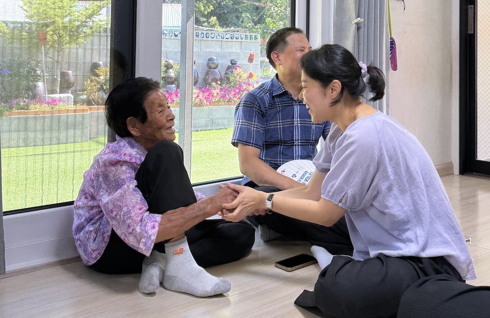 일본군&lsquo;위안부&rsquo;문제연구소 전략사업팀 담당자와 손을 잡고 이야기를 나누는 박필근 할머니