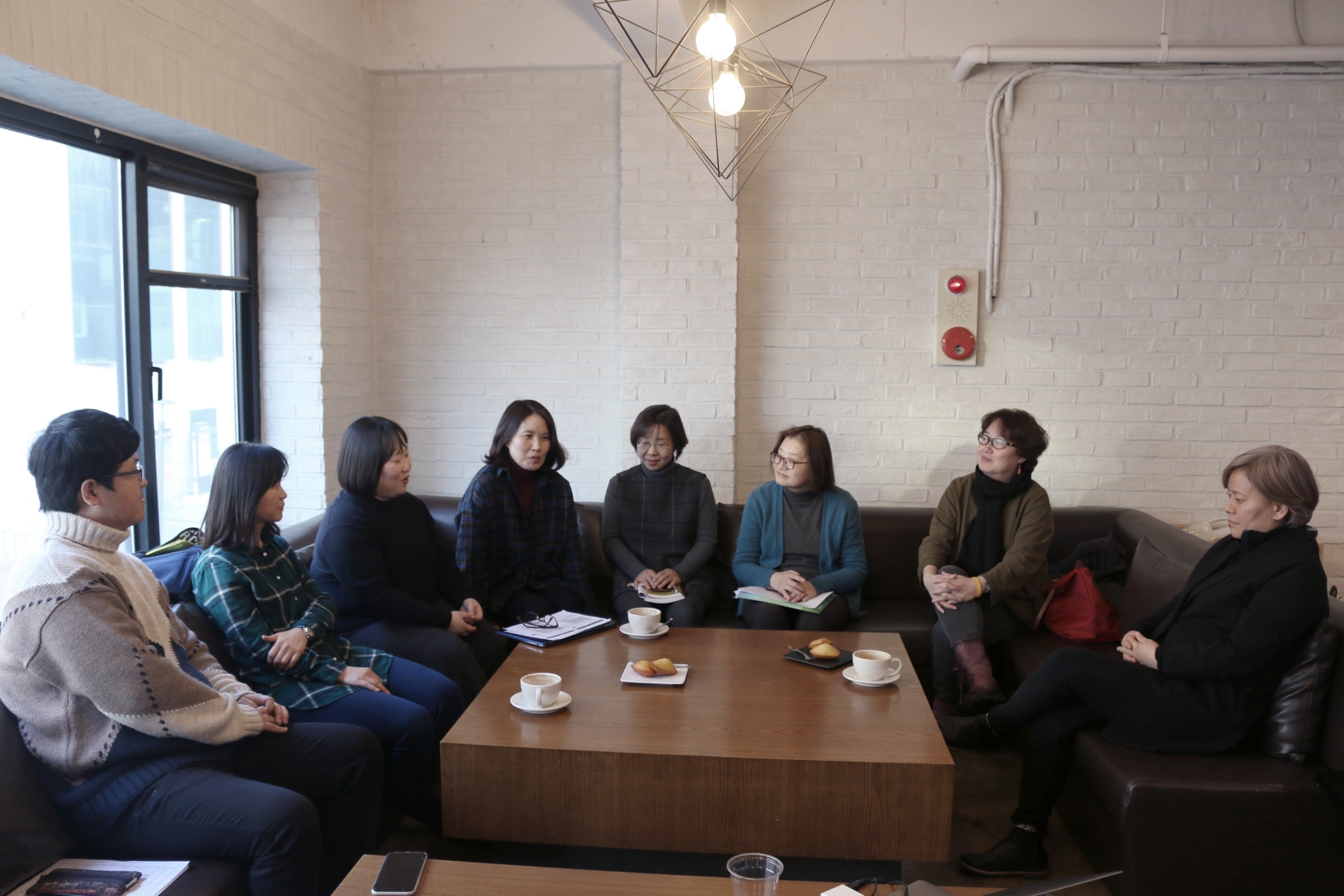 편집회의 현장 사진, 참석자 8명이 둘러 앉아있다.