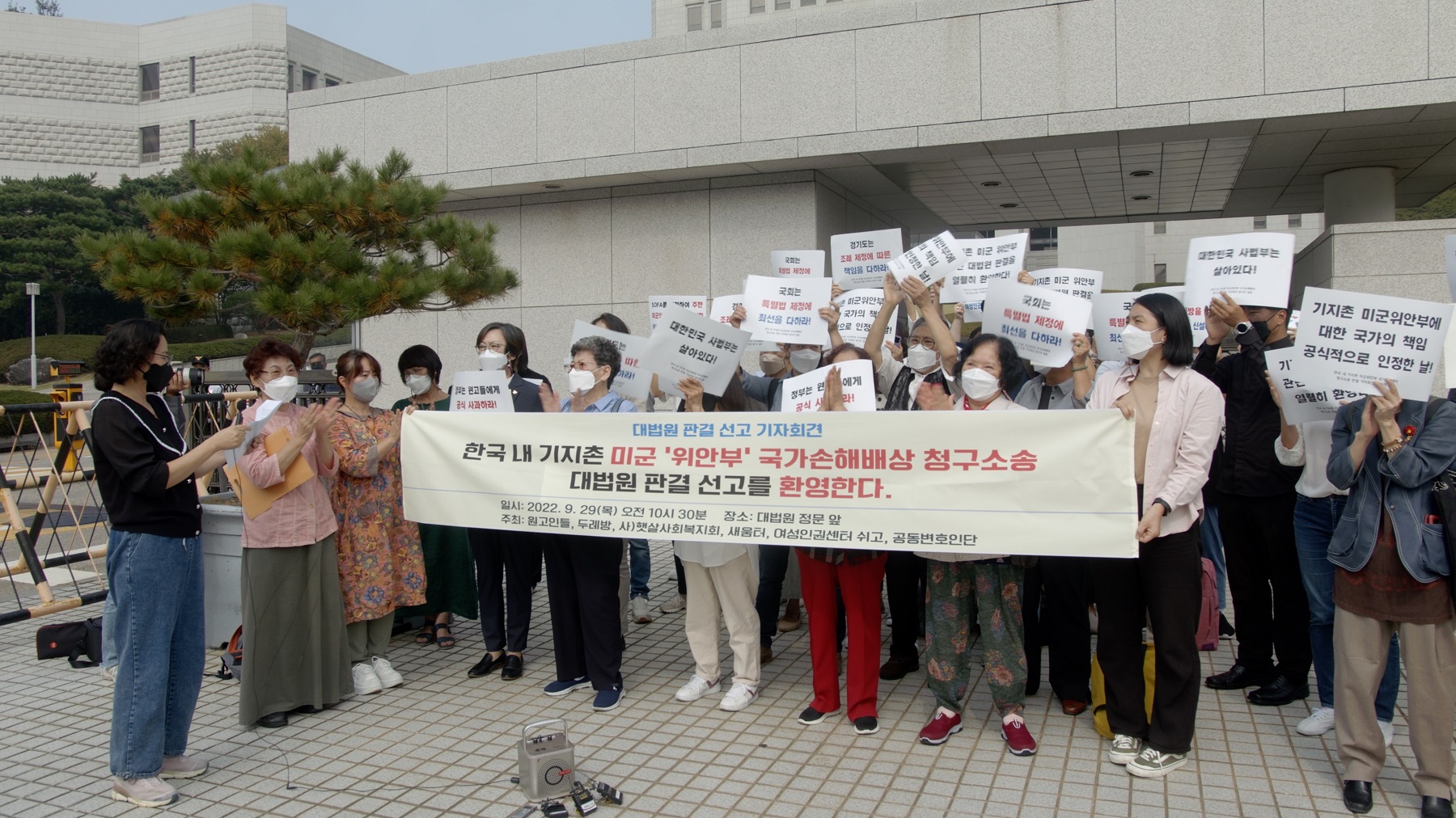 대법원 정문 앞에서 참석자들이 기자회견 현수막을 펼쳐 들고 박수를 치거나 &ldquo;대한민국 사법부는 살아있다!&rdquo;, &ldquo;국회는 특별법 제정에 최선을 다하라!&rdquo; 등의 손팻말을 들고 있는 모습.