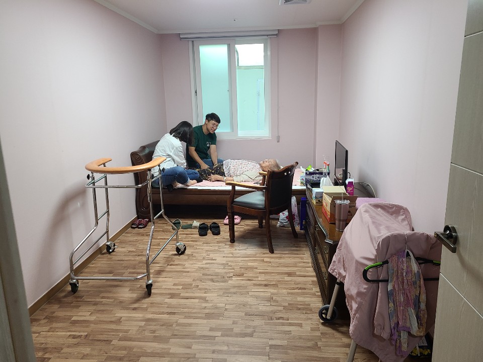 2020년 8월 11일 복원된 속리산 이옥선 할머니의 방이다. 창가 침대에 할머니가 누워 있고 그 곁에 두 사람이 앉아 이야기를 나누고 있다. 방 앞쪽에는 보행 보조기가, 오른쪽에는 텔레비전이 놓인 서랍장과 옷이 걸린 이동식 옷걸이가 있다.