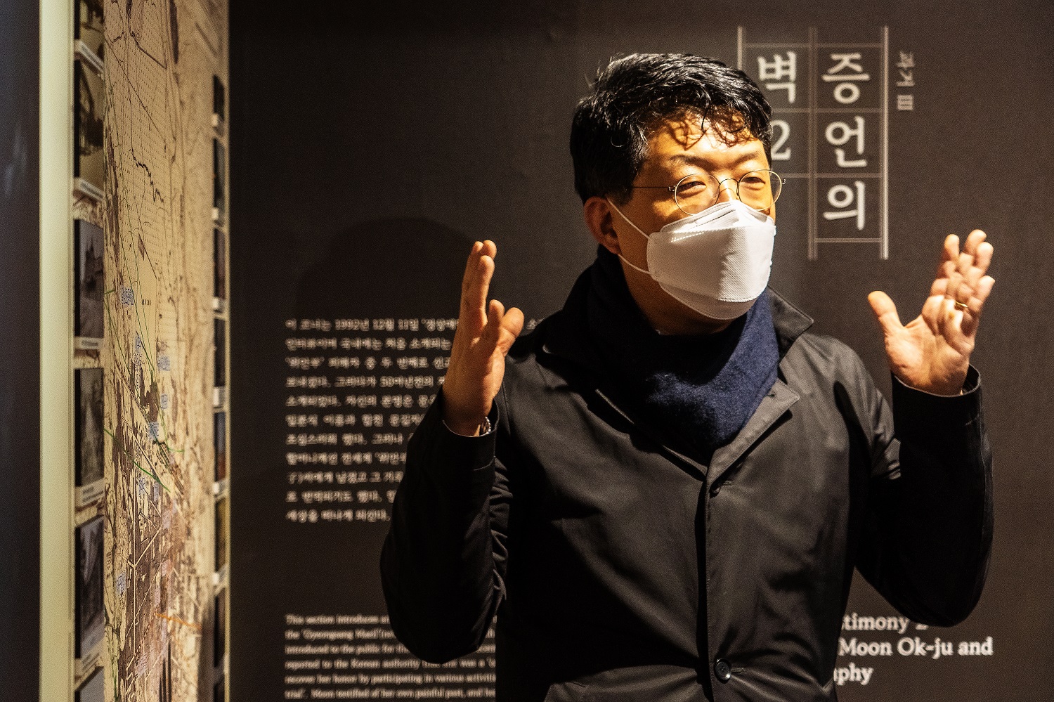 서혁수 대표가 문옥주 할머니의 증언을 소개하는 &lsquo;증언의 벽 2&rsquo; 앞에서 두 손을 들어 설명하고 있다.