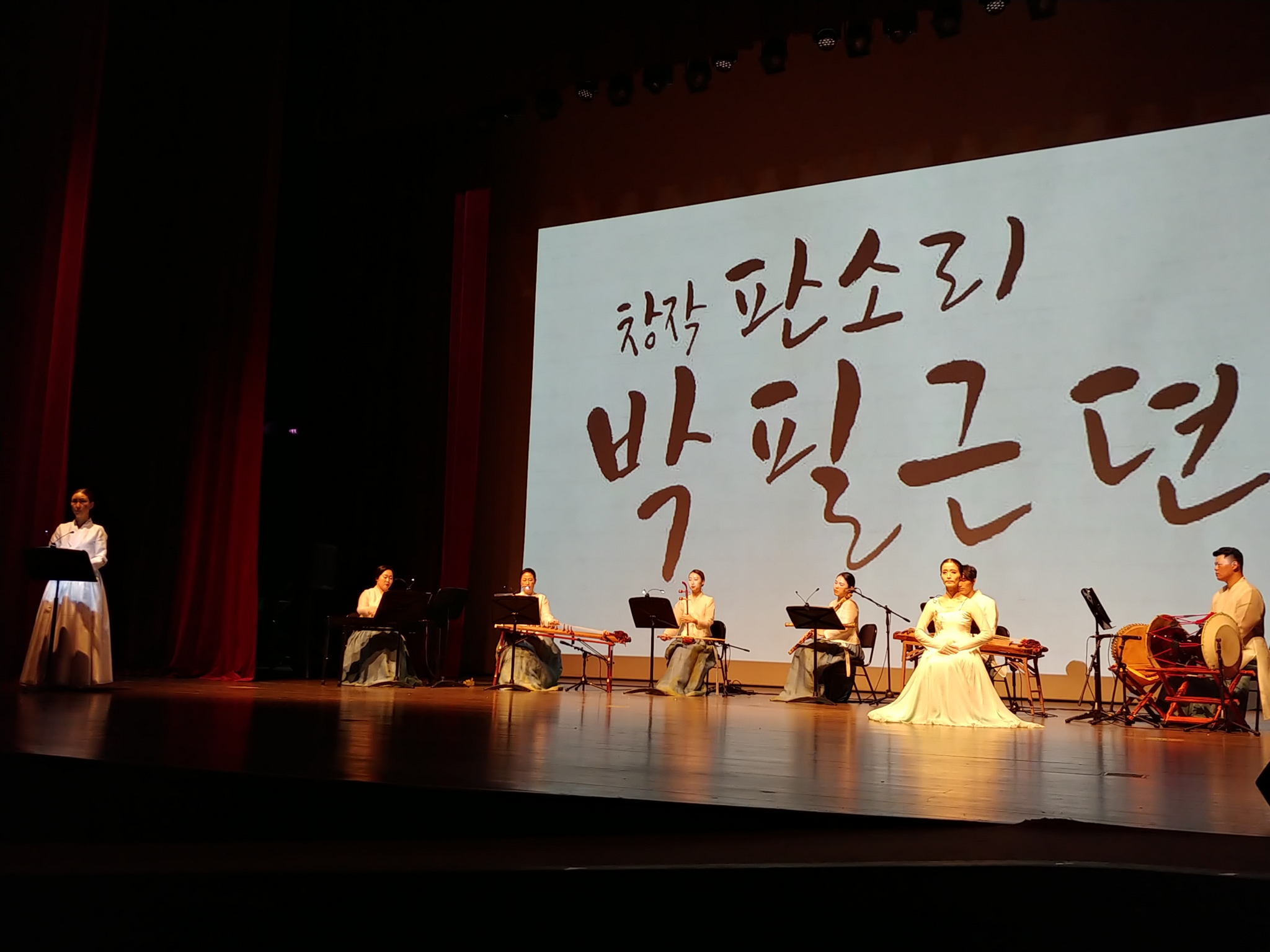 창작 판소리 박필근뎐 2020년 8월 14일 공연 사진. &ldquo;창작 판소리 박필근뎐&rdquo;이라는 글씨가 비친 대형 화면 앞에서, 한복을 입은 연주자들이 가야금과 해금, 북 등 국악기를 연주하고 있다. 무대 왼쪽 보면대 앞에는 낭독자가 서 있고, 오른쪽에는 흰 옷을 입은 무용수가 앉아 있다.