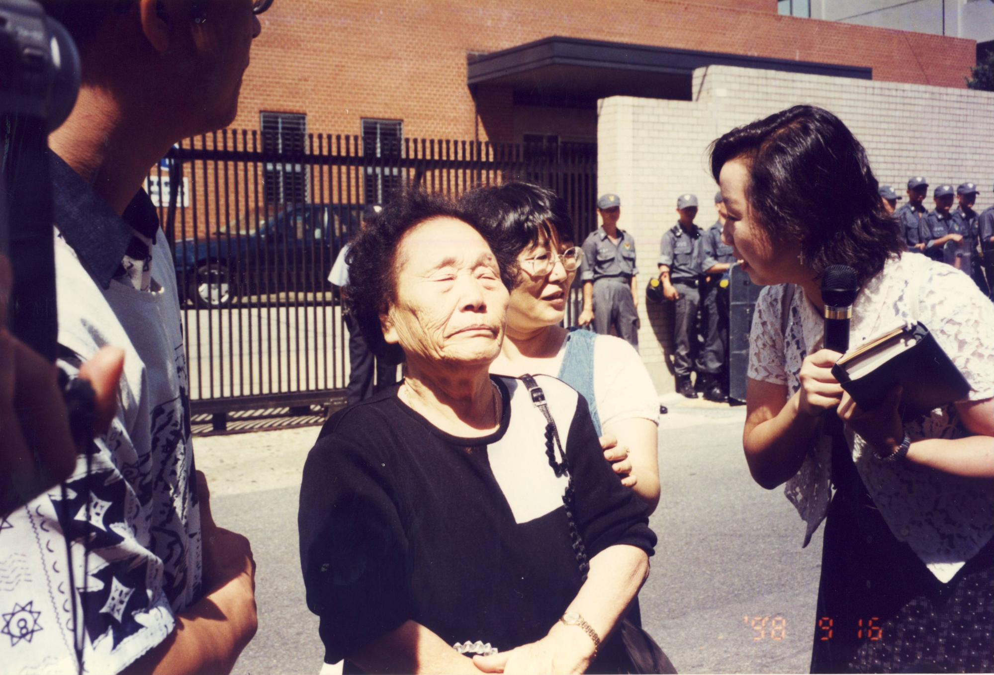 송신도가 1998년 9월 16일 서울 종로구 주한일본대사관 앞에서 열린 제330차 수요시위에 참석해 발언하던 중 눈을 감고 감정을 추스르고 있다. 오른쪽은 가와타 후미코. ⓒ한국정신