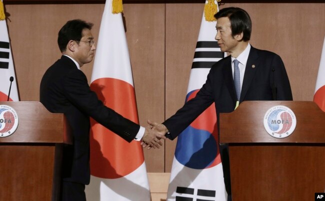 [Image 7] South Korean Foreign Minister Yun Byung-se (right) shaking hands with Japanese counterpart Fumio Kishida (left) after a joint press conference on the 2015 agreement (Image Source: VOA News)