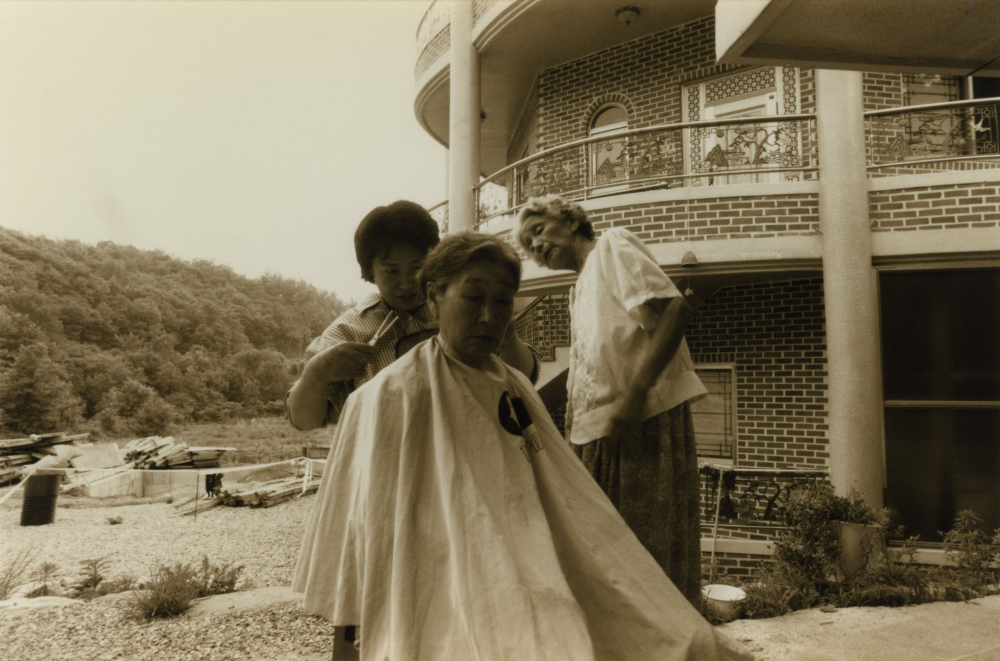 김복동이 나눔의집 야외에서 머리를 다듬고 있다. 오른쪽은 김순덕.  (사진 제공 : 나눔의 집)